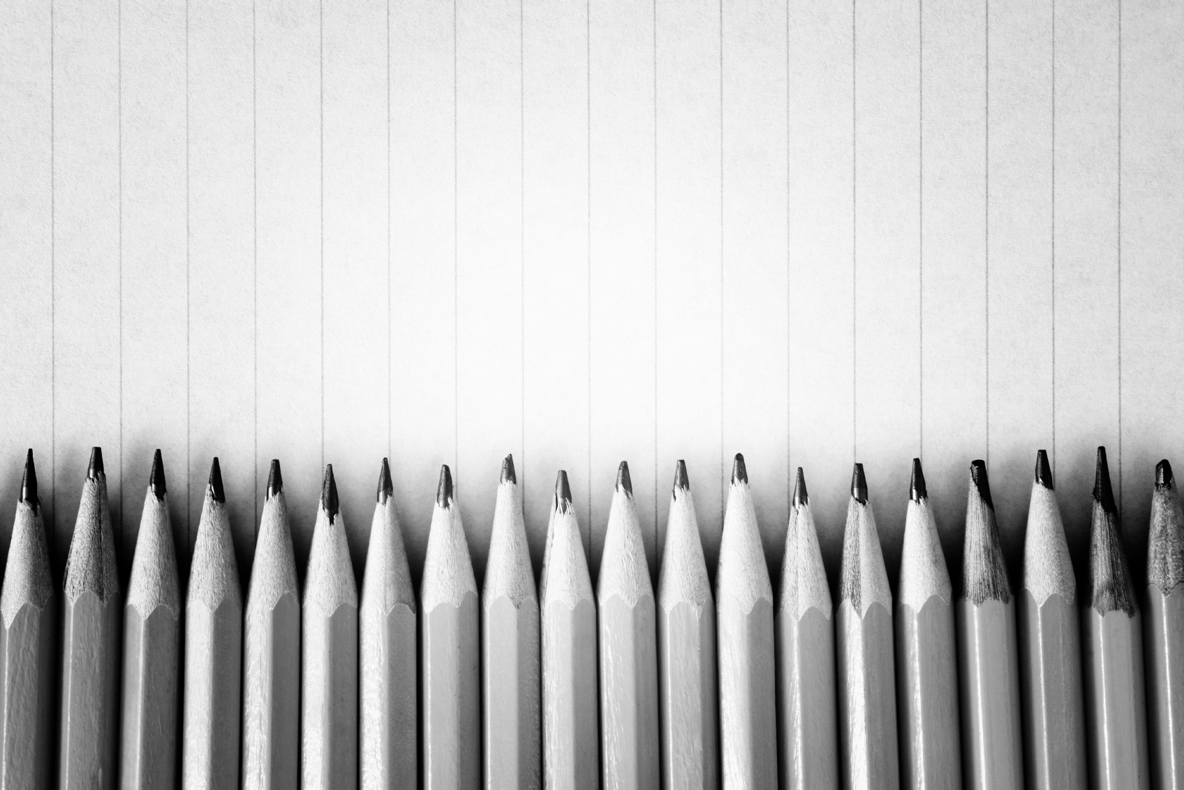 Sharpened pencils on a lined paper background