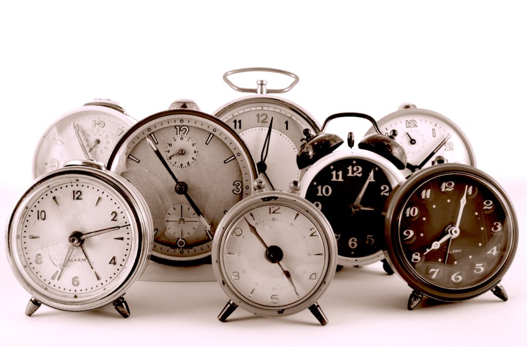 Analogue clocks set to different times on a white background