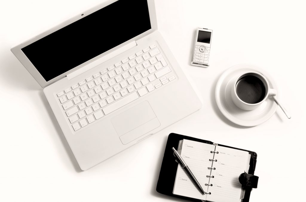 Flatlay of laptop, diary, phone and coffee cup