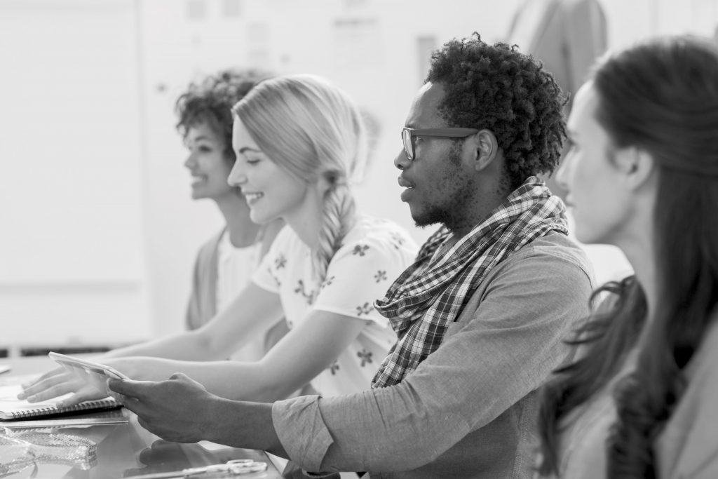 Creative designers listening to a presentation in bright creative office