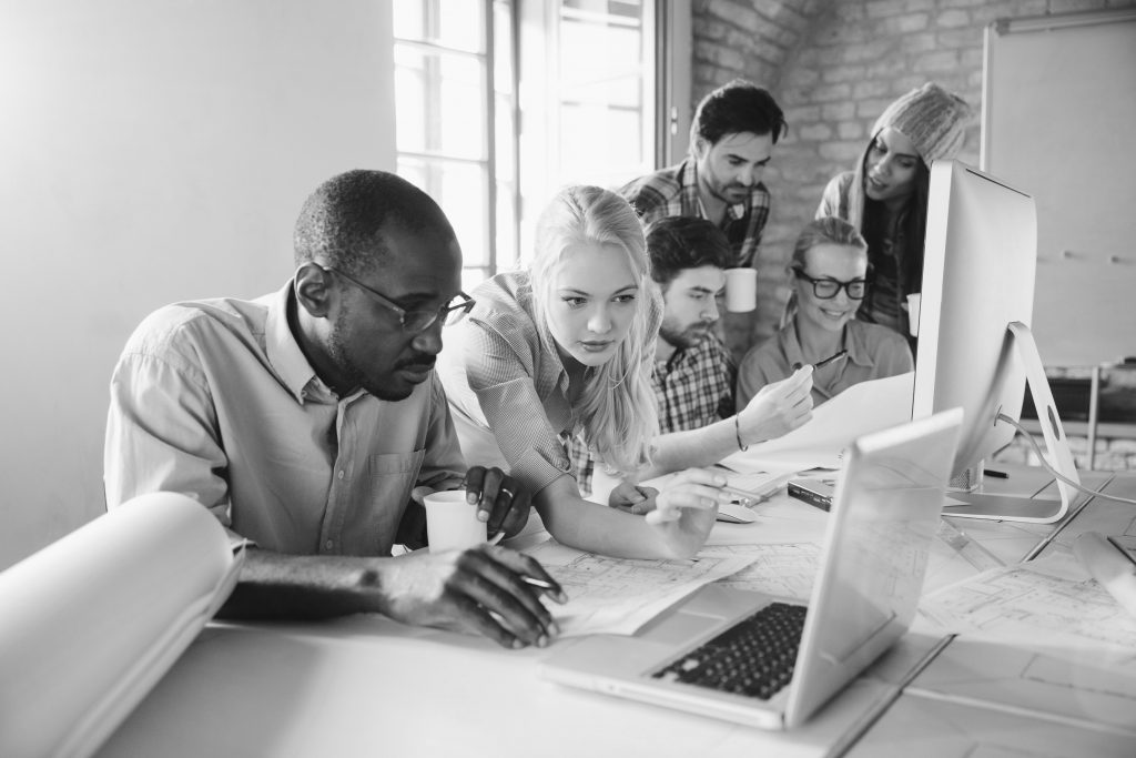 Young professionals brainstorming around a computer