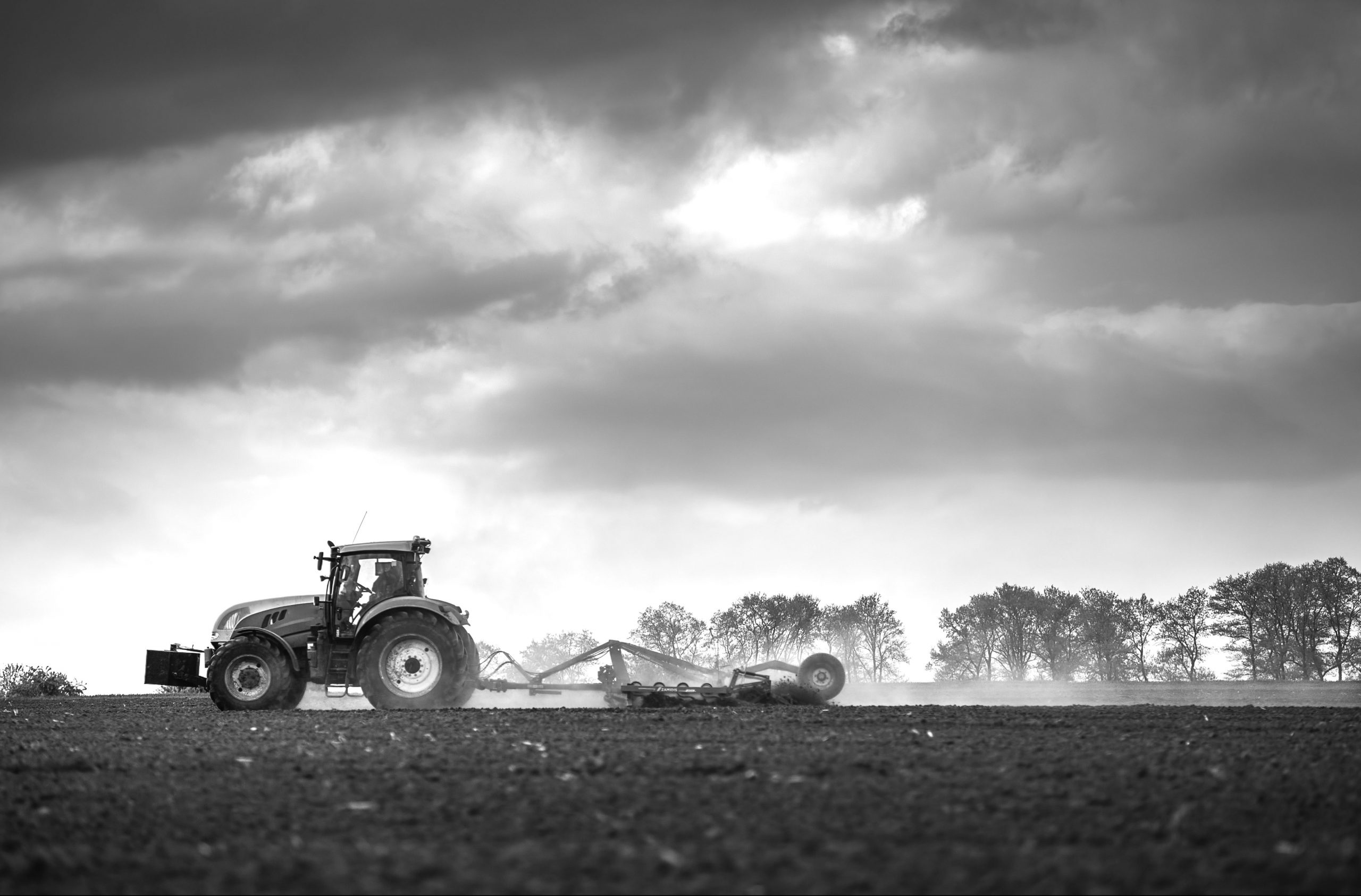 Farming tractor plowing and spraying on field