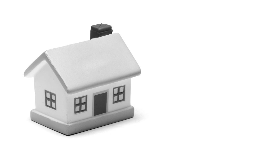 Miniature toy house on plain white background