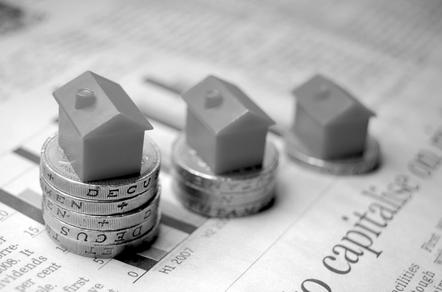 Monopoly houses balanced on one pound coins