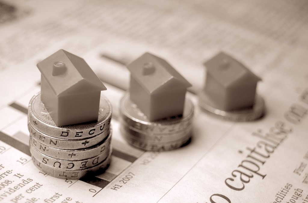 Monopoly houses balanced on one pound coins