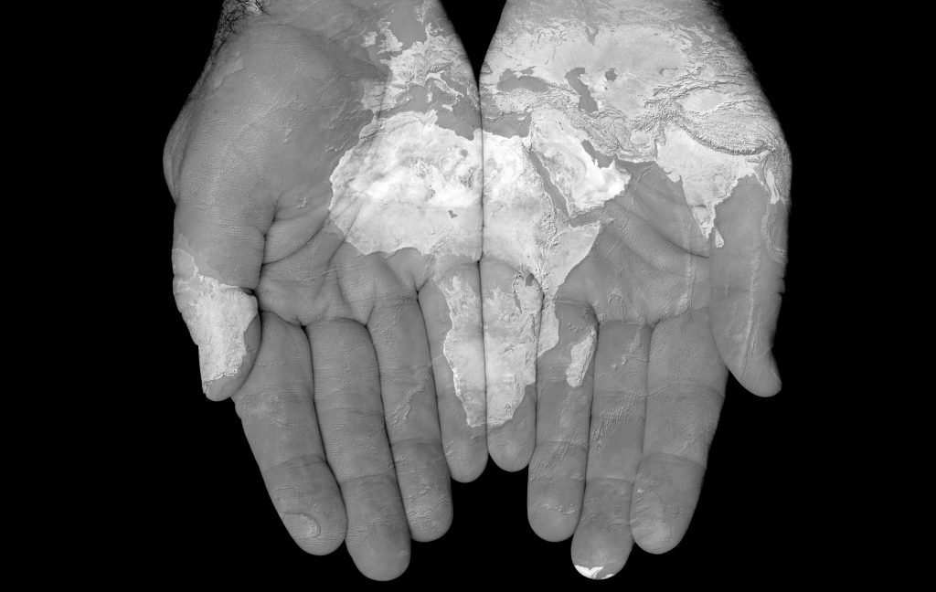 World map showing Africa painted on hands