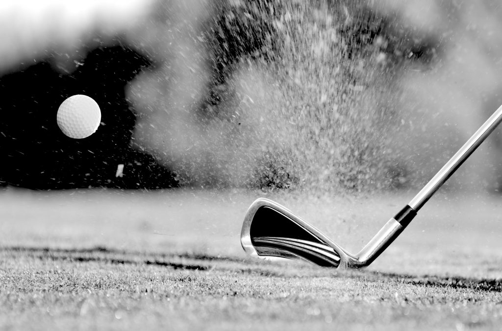 Close-up of golf ball with club during sunset