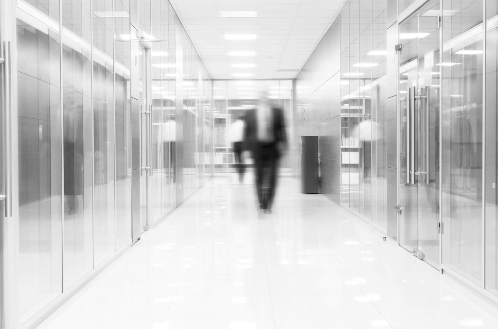 Businessman goes along a corridor at modern office