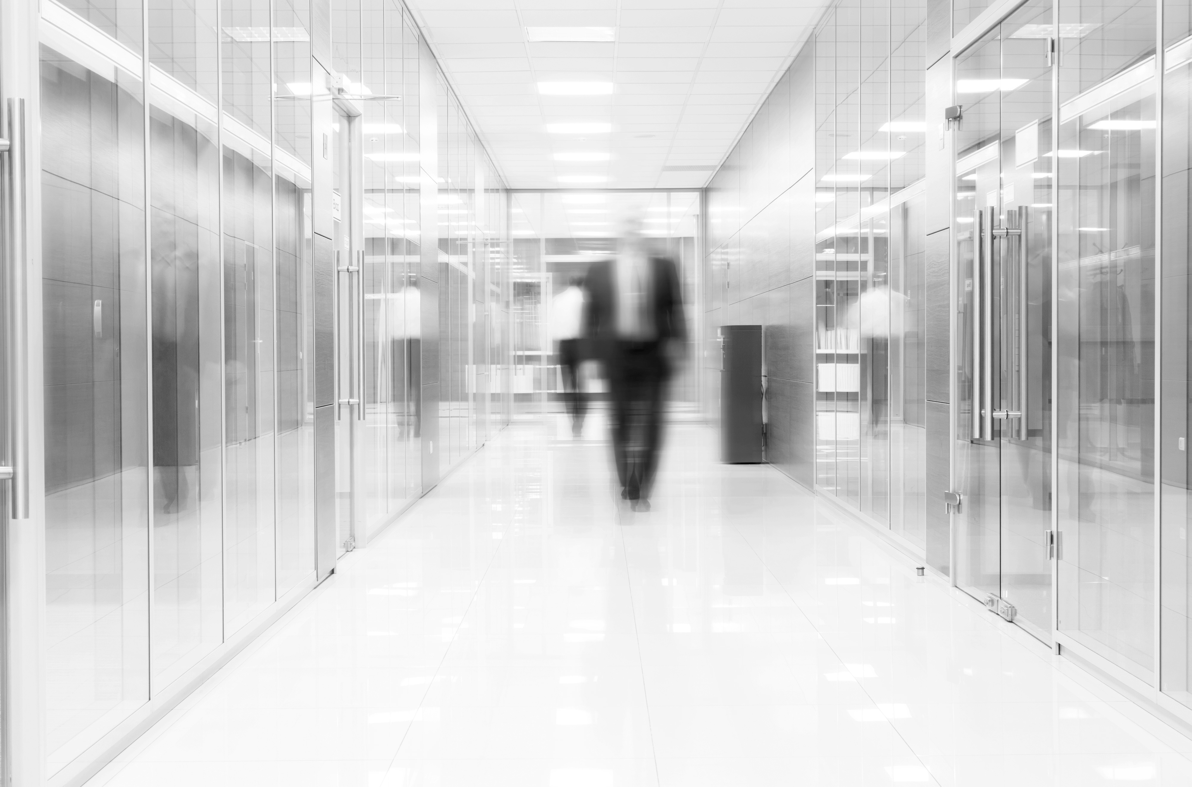 Businessman goes along a corridor at modern office