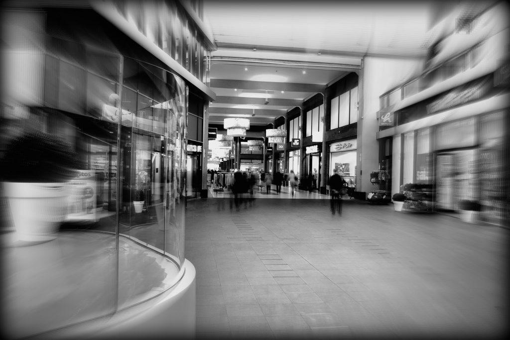 Shopping centre with glass shop front in foreground